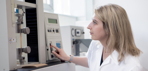 lab expert in front of a machine testing a packaging